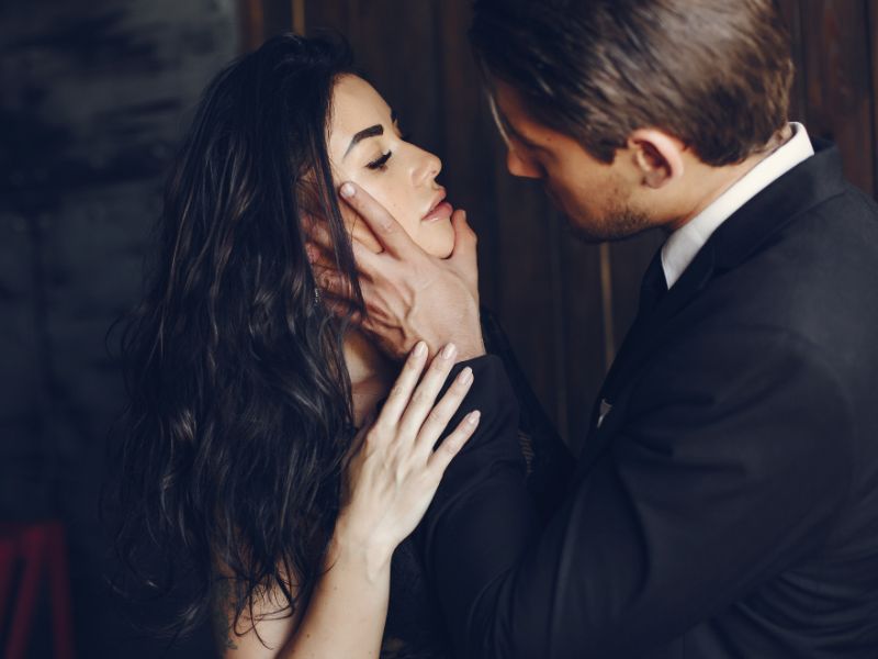Homme dominant qui tient une femme brune par le menton
