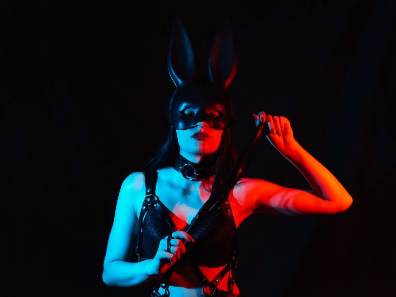 femme avec un masque de lapin et un collier BDSM lors d'un jeu petplay