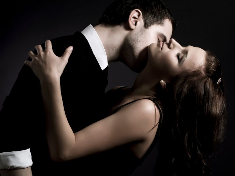 homme en costume qui embrasse une femme dans le cou