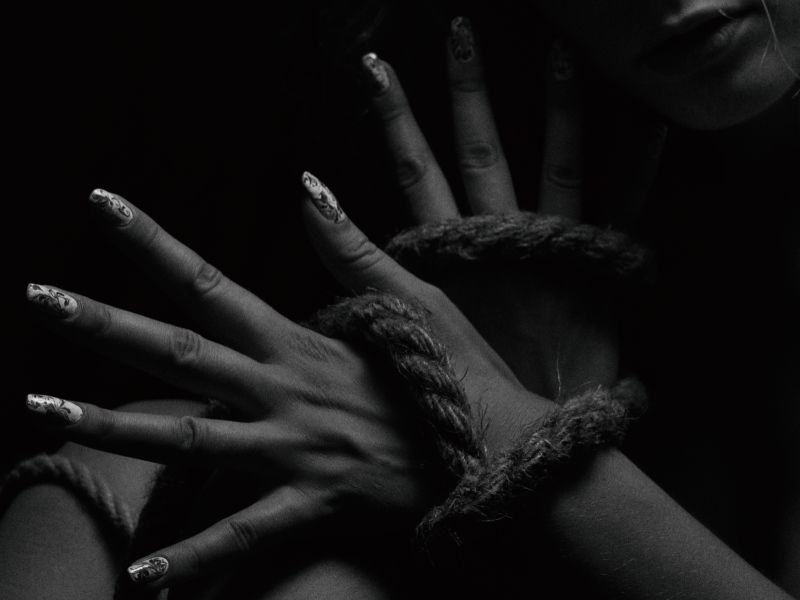 Mains de femmes attachées avec une corde de bondage